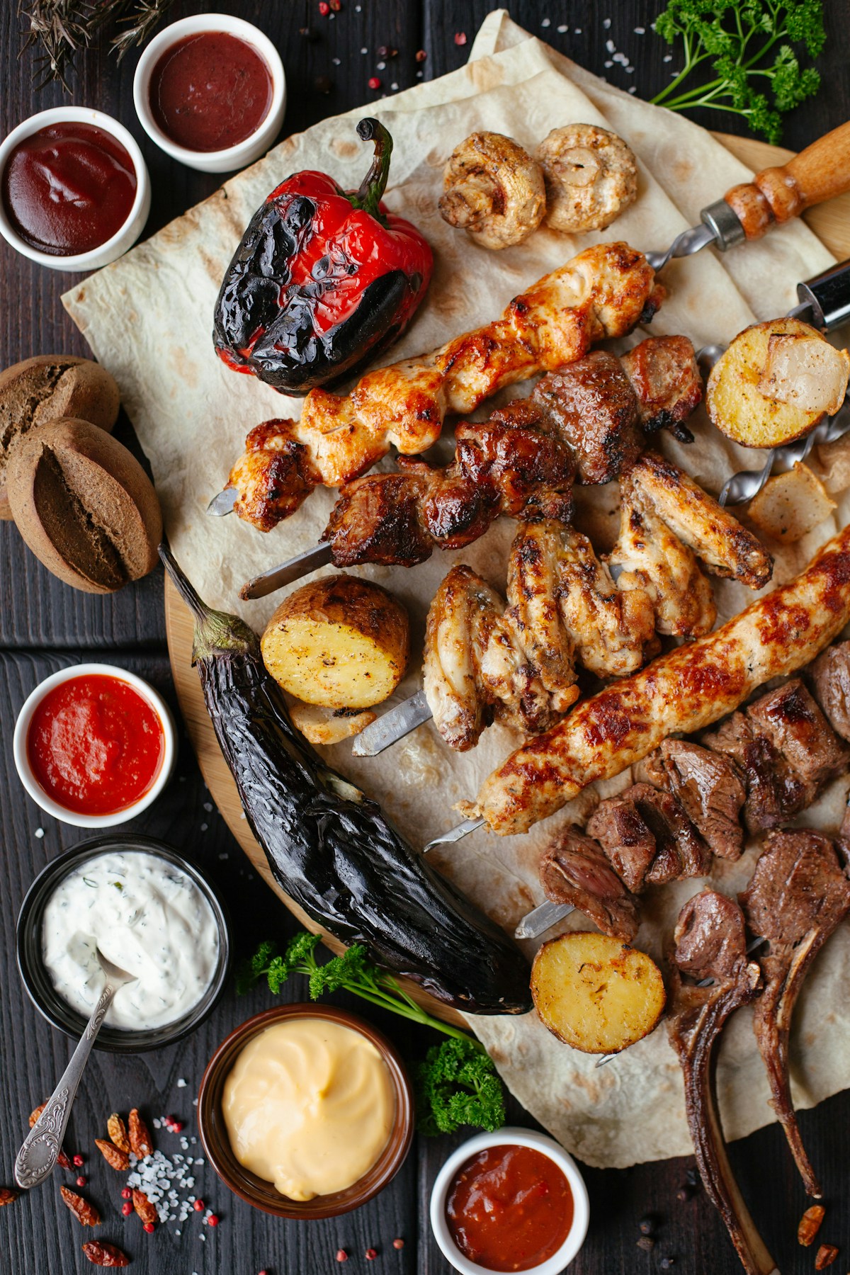 Brochetas, verduras y salsas para una mesa de sabores variados